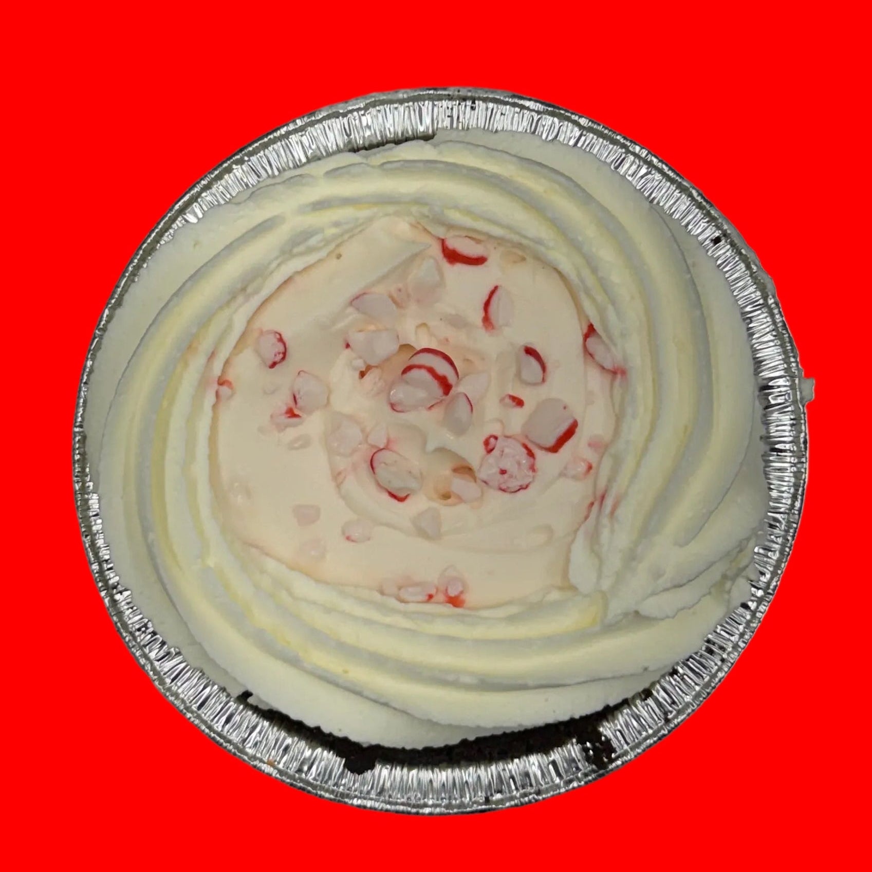 Small pie in a foil tin on a red background