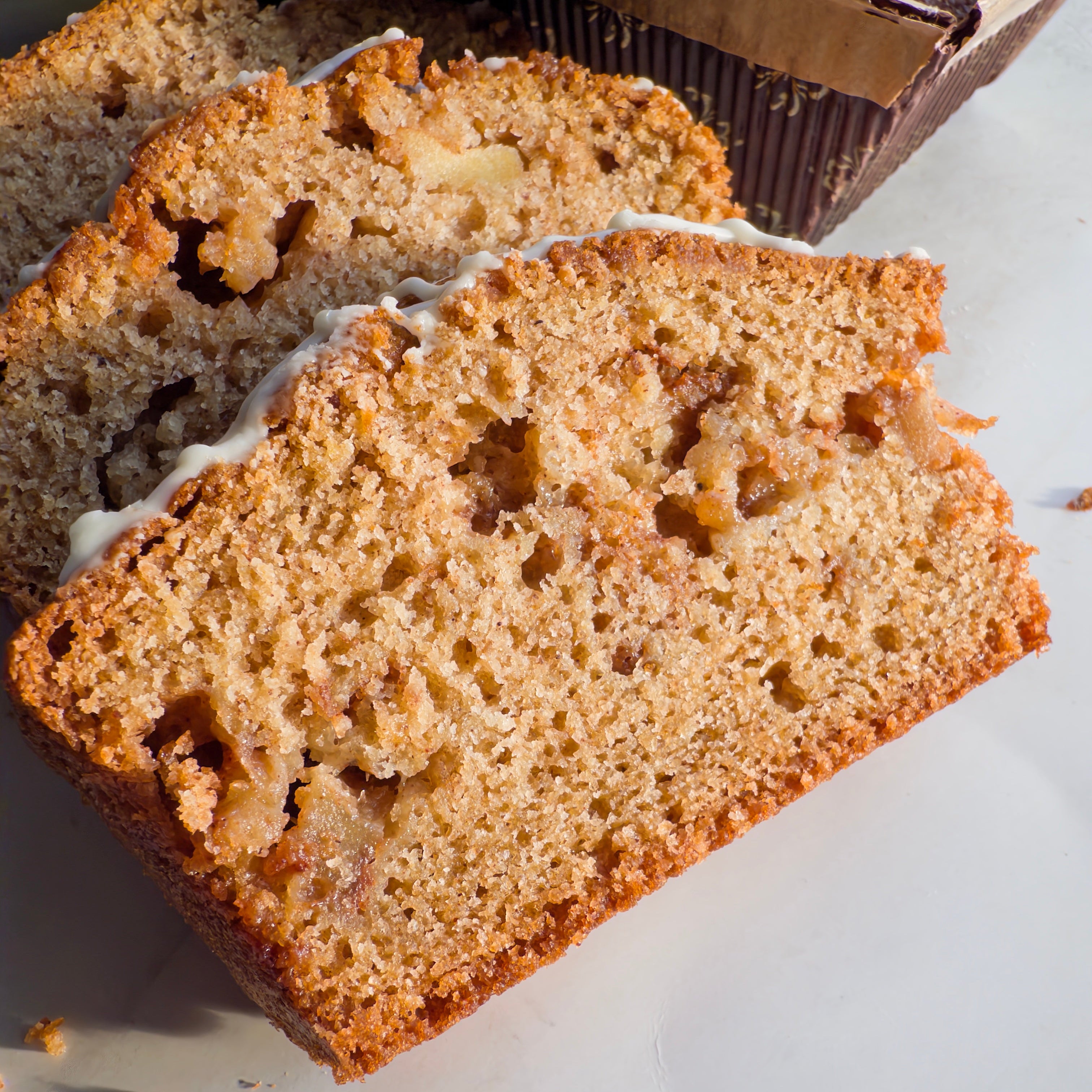 Sliced loaf of bread with a white glaze on a light surface